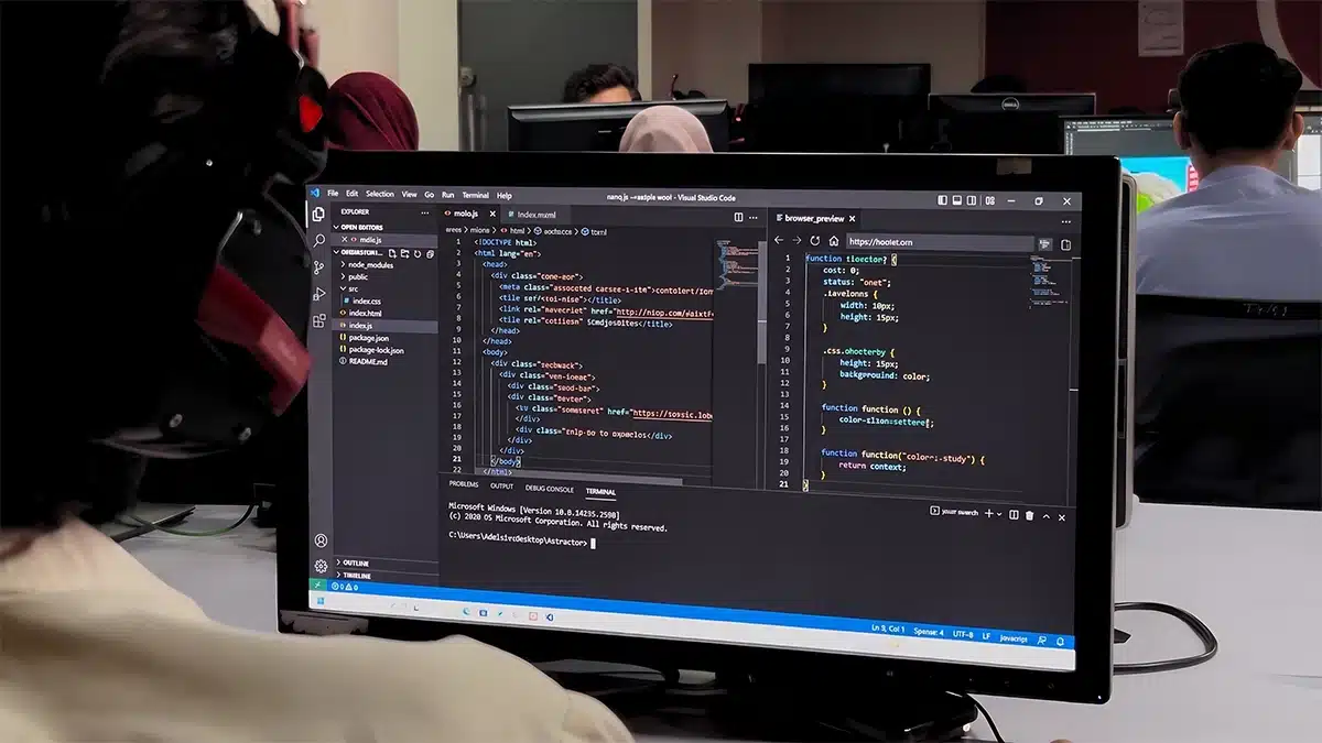 Web development course in Rawalpindi — a student writing HTML and JavaScript in a code editor in a computer lab